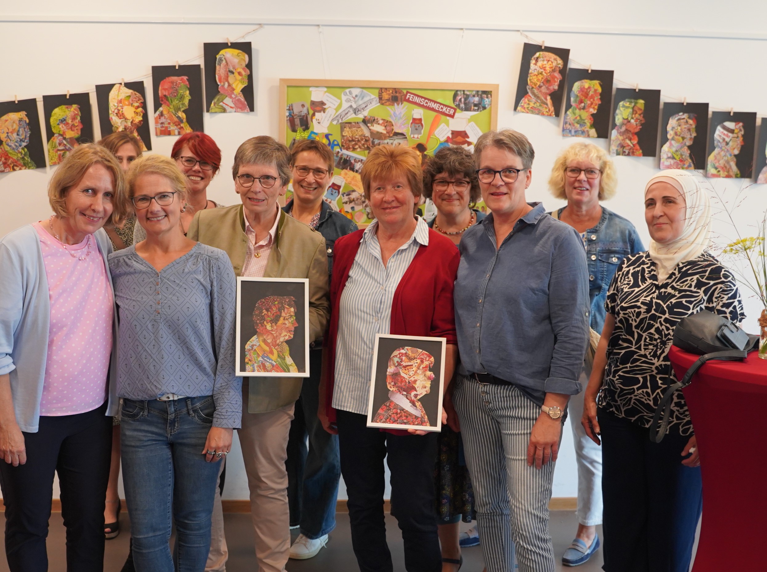 Das Mensateam präsentiert sich feierlich. Im Zentrum Frau von Fallois und Frau Strohmeyer mit ihren farbenfrohen Portraits