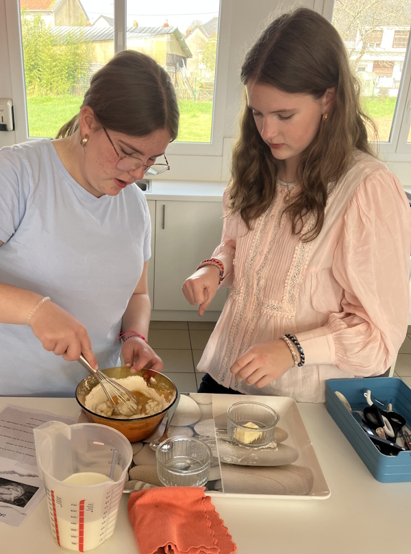 Zwei Schülerinnen beim Vorbereiten des Crepes Teigs